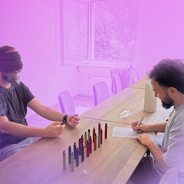 Two people in a vape blind test at a wooden table with several e-cigarettes in a row, laboratory setting, 20 mg