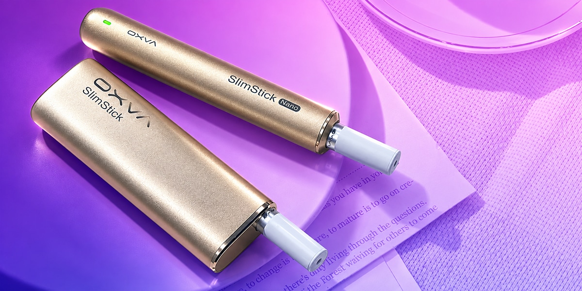 Zwei OXVA SlimStick und SlimStick Nano Vapes in Gold mit weißen Mundstücken auf lila Untergrund, 20 mg